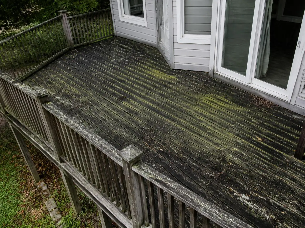Terrasse en bois envahie de mousse et de salissures avant nettoyage