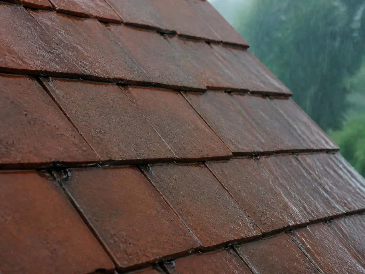 Tuiles poreuses sous la pluie : l'eau pénètre et fonce le matériau avant traitement