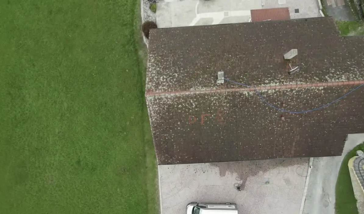 Toiture couverte de mousses et lichens vue par drone avant intervention